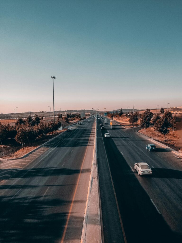 Aerial view of a highway in Amman, Jordan during the day with light traffic and clear skies.